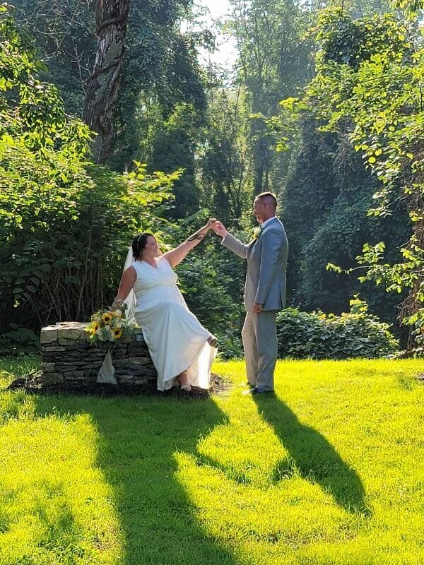 A bride and groom holding hands in the grass at The 228 in Sterling, MA.